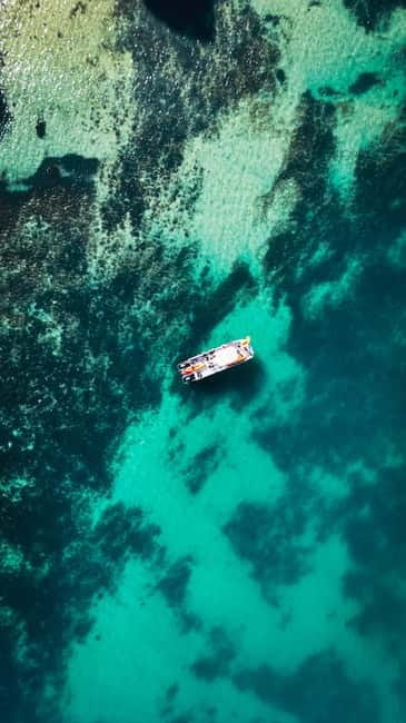 From Lagos: Ponta da Piedade Caves Kayak Tour from Catamaran - Sliding into the kayak at the cliffs