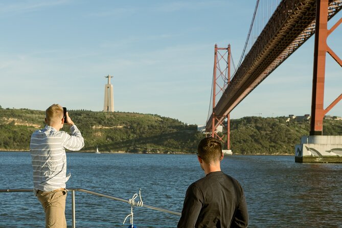 Lisbon: Sunset Catamaran Boat Tour with Music and Drinks - The 25th of April Bridge frames the opening view
